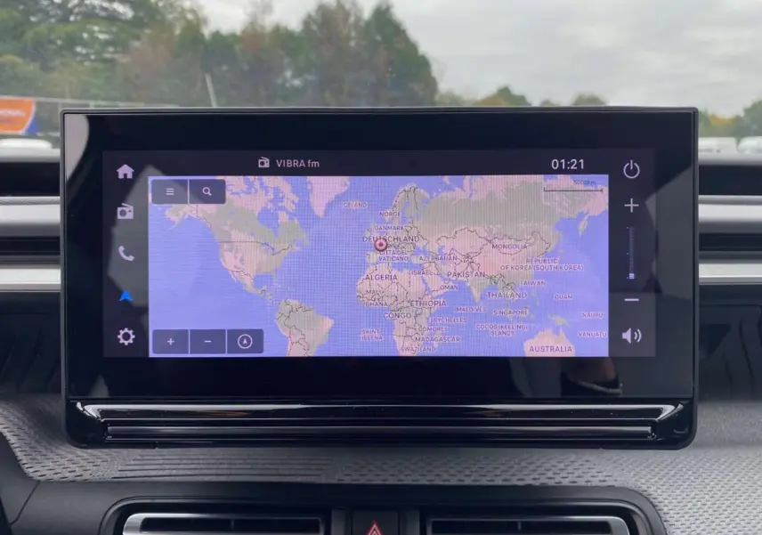 Écran tactile central de la Citroën C3 2025 affichant une carte du monde avec interface moderne et commandes tactiles.