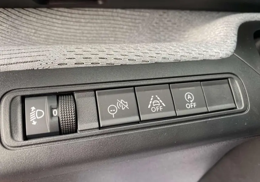 Gros plan sur les commandes noires du tableau de bord de la Citroën C3 rouge Elixir avec toit noir, version 2025.