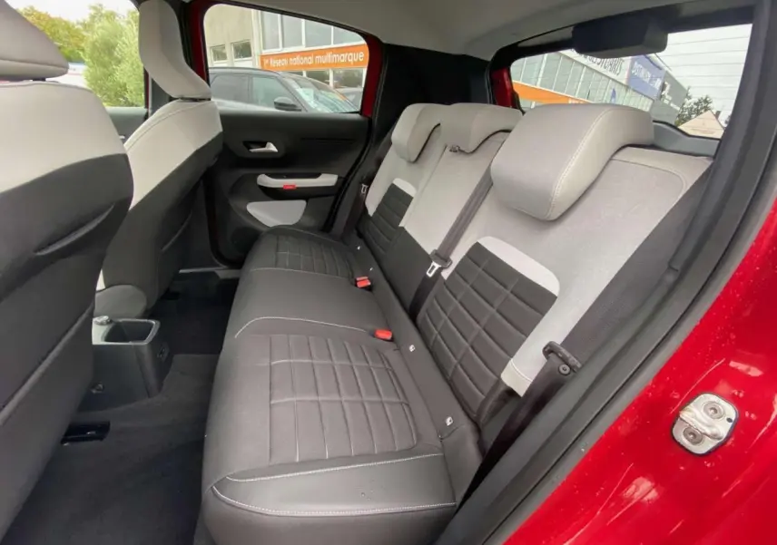 Vue intérieure côté droit de la banquette arrière noire et grise du Citroën C3 Rouge Elixir avec toit noir, 2025.