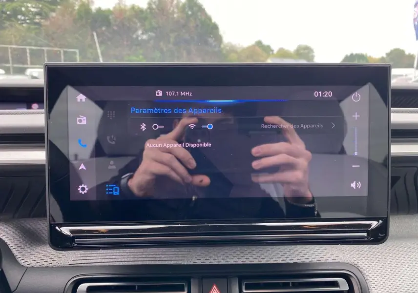 Écran tactile central de la Citroën C3 2025 affichant les paramètres Bluetooth, avec reflet des mains du conducteur.