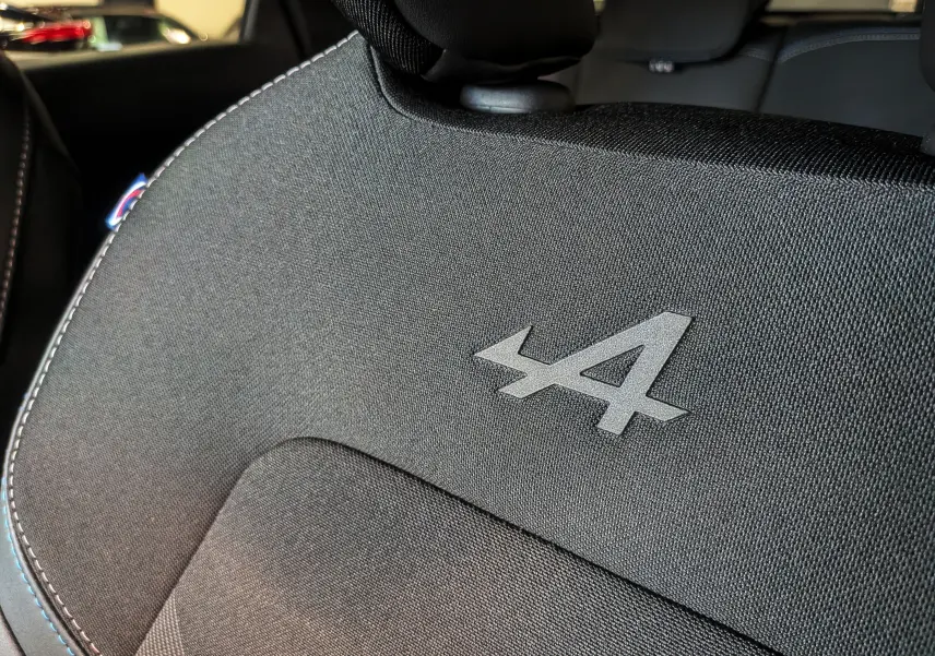 Gros plan sur l'appui-tête arrière noir étoilé du Renault Captur E-TECH esprit Alpine avec logo Alpine embossé.