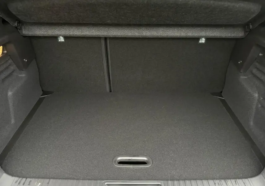 Coffre vide du Renault Captur 2025, vue intérieure arrière, avec plancher de coffre mobile et revêtement noir.