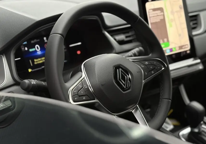 Vue rapprochée du volant noir et du tableau de bord digital du Renault Captur 2025 avec écran tactile vertical.