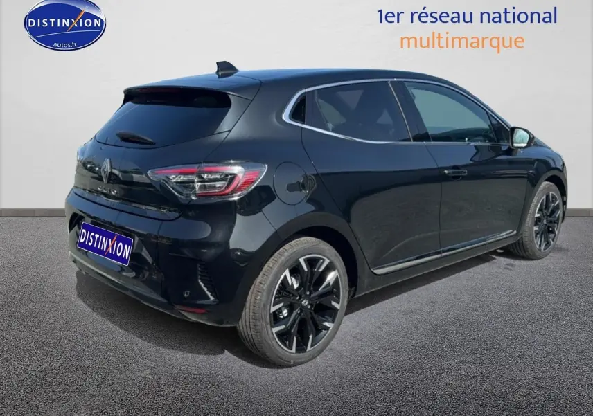 Renault Clio V noire vue 3/4 arrière droit, jantes alliage noires et becquet arrière distinctif.