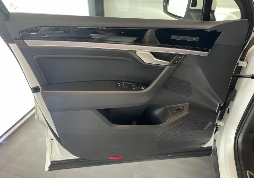 Vue intérieure côté gauche de la porte avant blanche du Volkswagen Touareg 2019 avec garniture noire et inserts laqués.