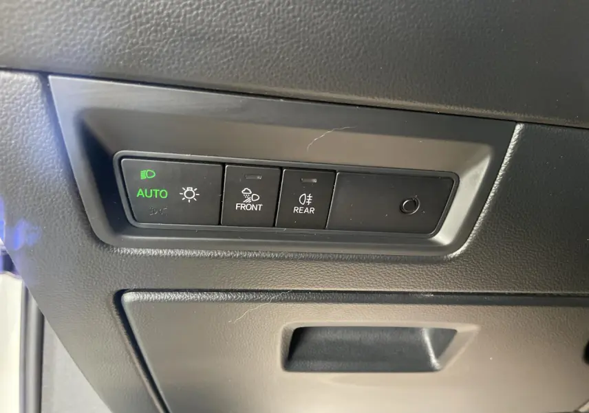 Gros plan sur les commandes d’éclairage et anti-brouillard du Volkswagen Touareg blanc, intérieur côté conducteur.