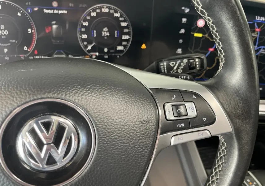Gros plan sur le volant cuir noir R-Line avec commandes multifonctions et tableau de bord numérique du Volkswagen Touareg 2019.