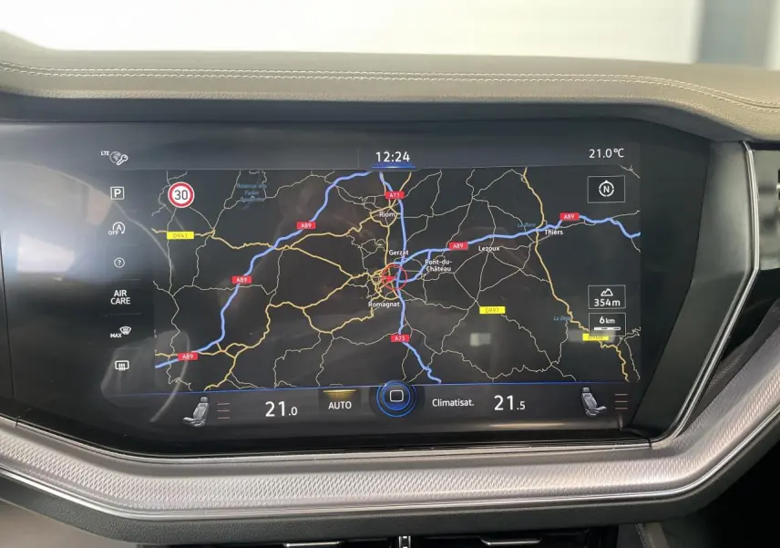 Écran tactile central du Volkswagen Touareg 2019 affichant la navigation et la climatisation, entouré de finitions argentées.