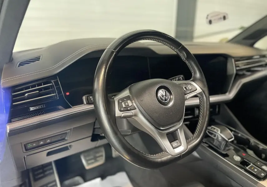 Vue intérieure du volant cuir noir multifonction Volkswagen avec tableau de bord et console centrale du Touareg 2019.