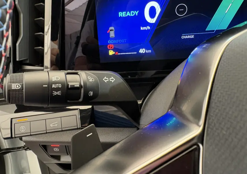 Gros plan sur le combiné d'instruments numérique bleu et la commande des phares du Renault Espace blanc esprit Alpine 2025.