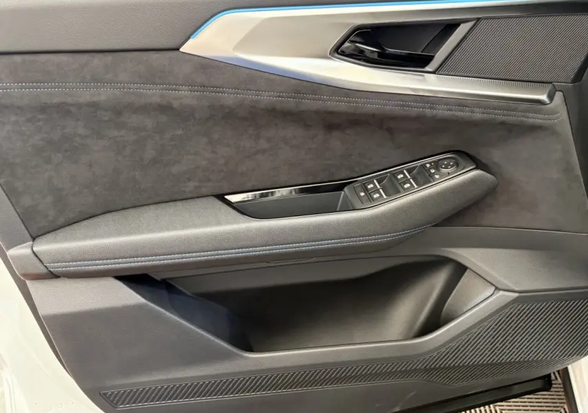 Détail de la porte avant gauche du Renault Espace blanc 2025, avec garniture noire et commandes de vitres intégrées.