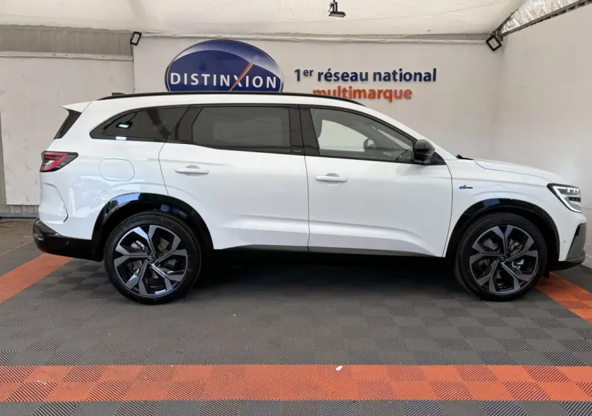 Vue latérale droite d'un Renault Espace blanc esprit Alpine 7 places avec jantes noires et vitres teintées.