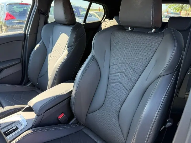 Gros plan sur les sièges avant sport en cuir noir avec surpiqûres blanches d'une BMW Série 1 120dA M Sport 2025.
