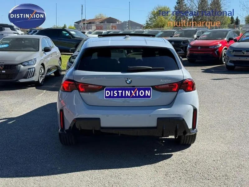 Vue arrière d'une BMW Série 1 120dA M Sport en gris Brooklyn métallisé, avec feux arrière LED et diffuseur noir.