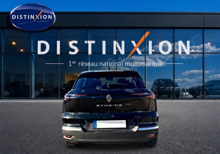 Vue arrière d'un Renault Symbioz noir étoile 2026, avec feux arrière LED et logo centré sur un parking devant un showroom Distinxion.