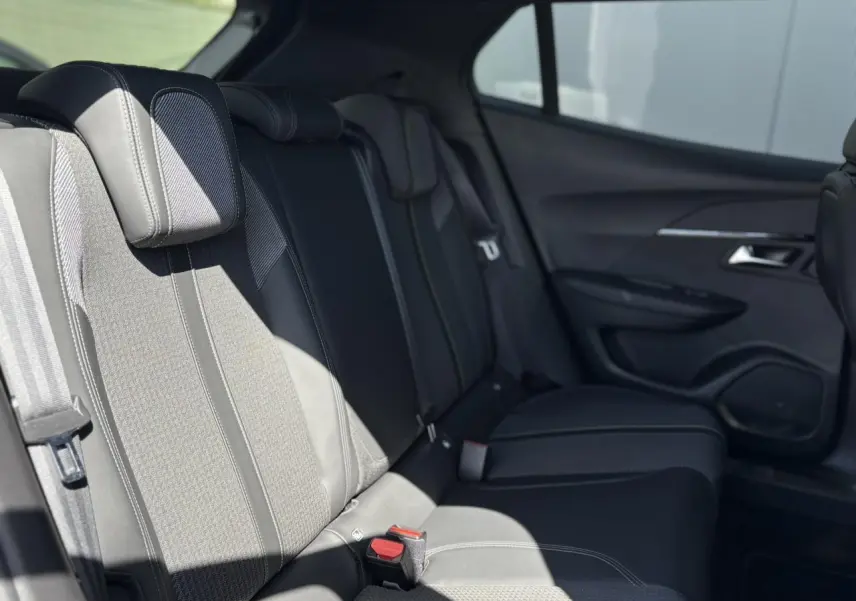 Vue latérale droite de l’habitacle arrière du Peugeot 2008 1.5 BlueHDI GT, sièges noirs et garnitures tissu/TEP.