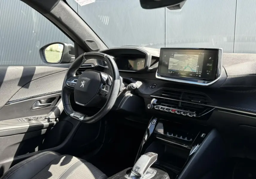 Vue intérieure côté conducteur du Peugeot 2008 noir Onyx, mettant en valeur le volant compact, l'écran tactile GPS et la console centrale moderne.
