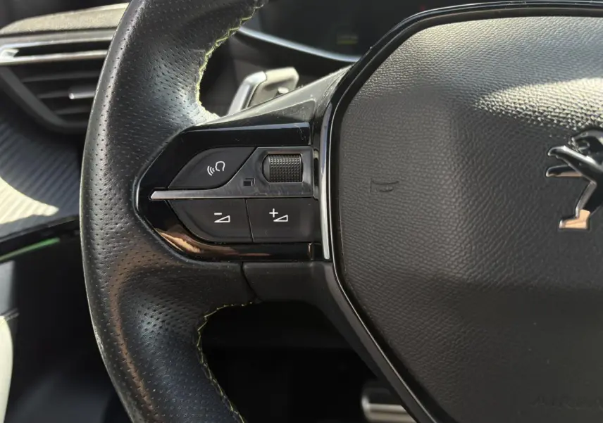 Gros plan sur la partie gauche du volant cuir noir perforé avec surpiqûres vertes du Peugeot 2008 GT 2021.