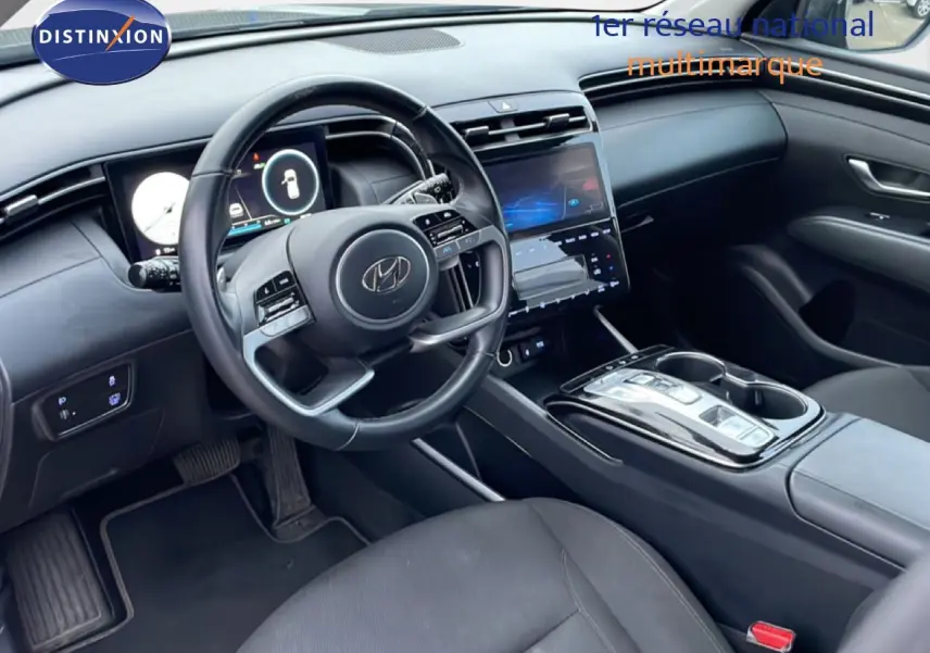 Vue intérieure côté conducteur du Hyundai Tucson 2023 avec tableau de bord numérique et console centrale tactile noire.