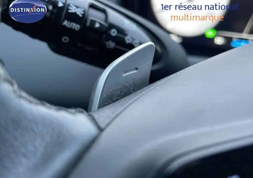Détail d'une palette de changement de vitesse grise sur le volant noir d'un Hyundai Tucson hybride 2023.
