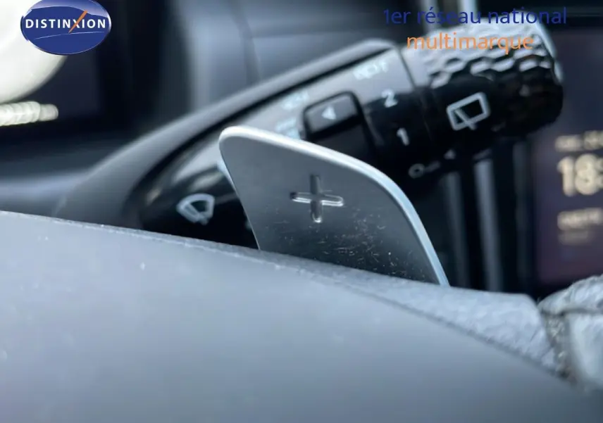 Gros plan sur la palette de changement de vitesse "+" côté droit du volant du Hyundai Tucson 2023 hybride.