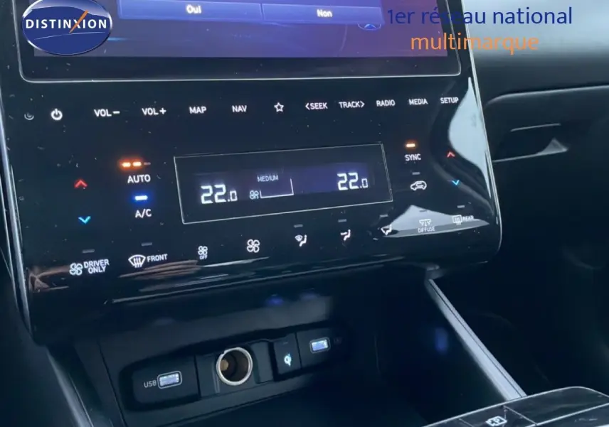 Détail du tableau de bord noir du Hyundai Tucson 2023, affichage digital de la climatisation à 22°C.