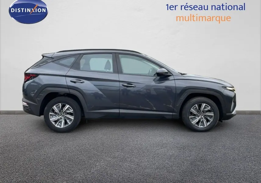Vue de profil droit du Hyundai Tucson 2023 hybride en finition Business, couleur Dark Knight Metal avec jantes alliage.