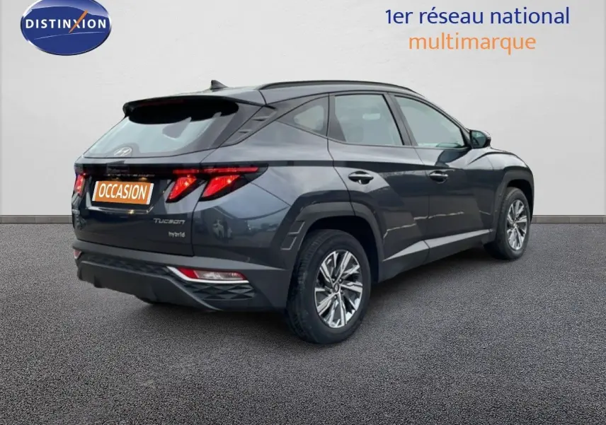 Vue 3/4 arrière droite d'un Hyundai Tucson 2023 hybride en couleur Dark Knight Metal avec feux arrière LED distinctifs.
