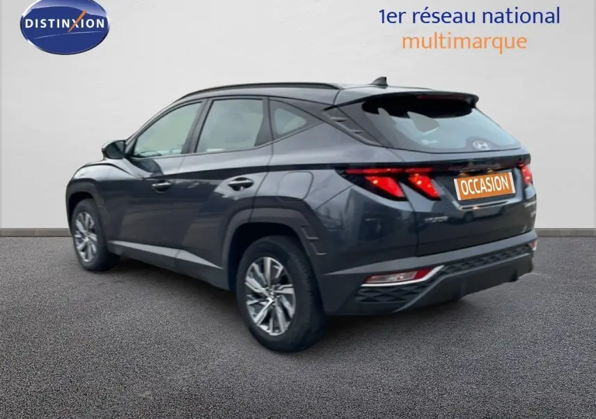Vue 3/4 arrière droite d'un Hyundai Tucson 2023 hybride en gris foncé Dark Knight Metal avec feux arrière LED distinctifs.