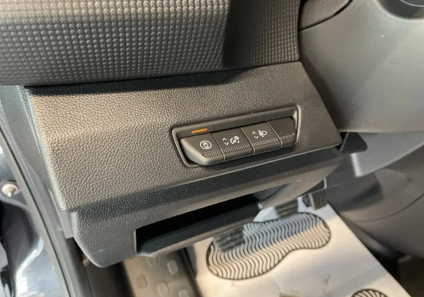 Gros plan sur les commandes de réglage d’éclairage et tableau de bord côté conducteur du Renault Trafic Fourgon gris Comète.