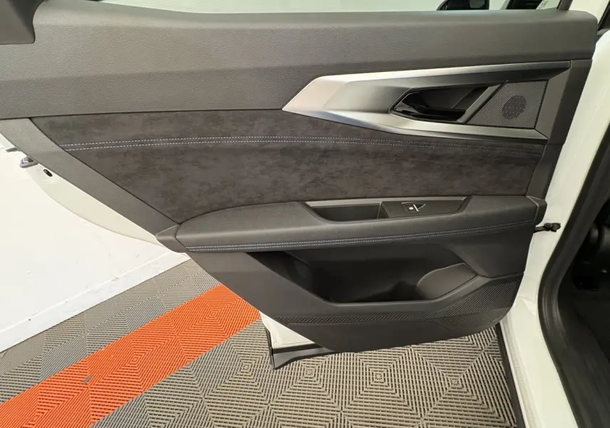 Vue latérale du panneau de porte avant gauche blanc du Renault Espace esprit Alpine avec garniture noire et surpiqûres bleues.