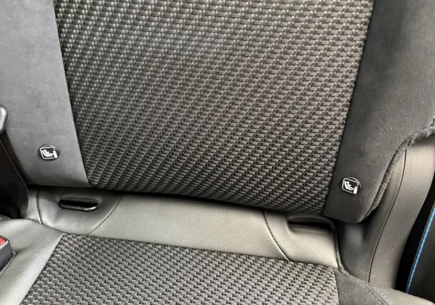 Gros plan sur le tissu et cuir noir du siège arrière avec indication Isofix sur Renault Espace Esprit Alpine blanc.