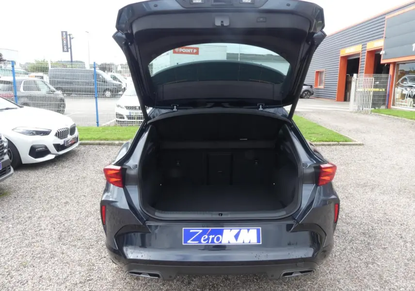 Vue arrière ouverte du coffre du CUPRA Formentor gris magnétique 2025, avec feux arrière LED et double sortie d’échappement noire.