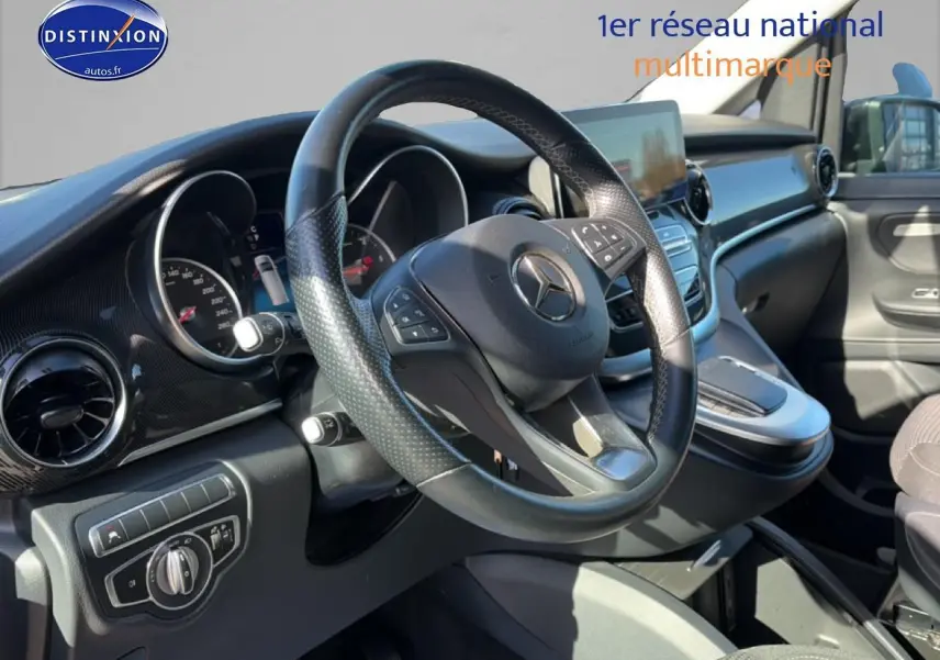 Vue intérieure de face du poste de conduite noir du Mercedes Classe V 220 d long style avec volant multifonction.