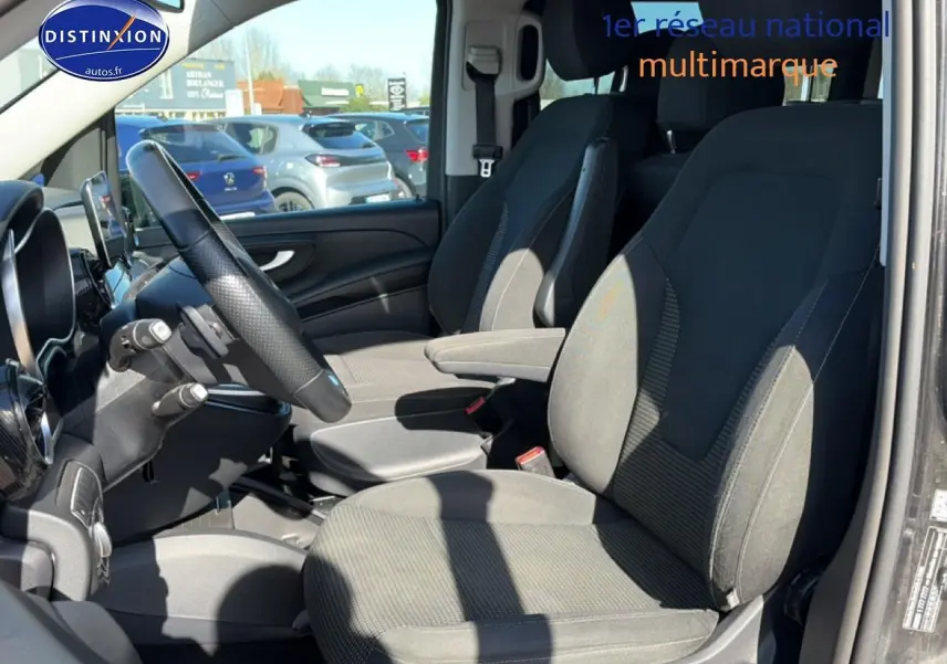 Vue intérieure côté conducteur du Mercedes Classe V 220 d long noir, sièges tissu Santos noirs et volant multifonction.