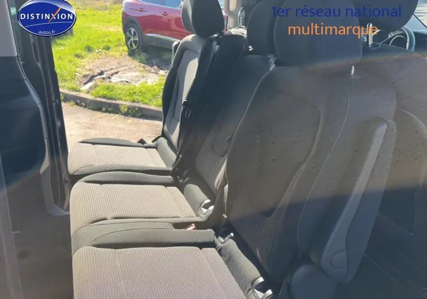 Vue intérieure sur les sièges arrière en tissu noir du Mercedes Classe V 220 d long, porte latérale coulissante ouverte.