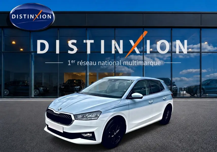 SKODA FABIA blanche vue 3/4 avant droit avec jantes noires devant vitrine Distinxion.