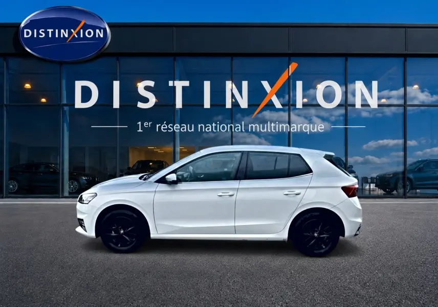Skoda Fabia blanche vue de profil côté gauche, jantes alu noires, devant vitrine Distinxion.