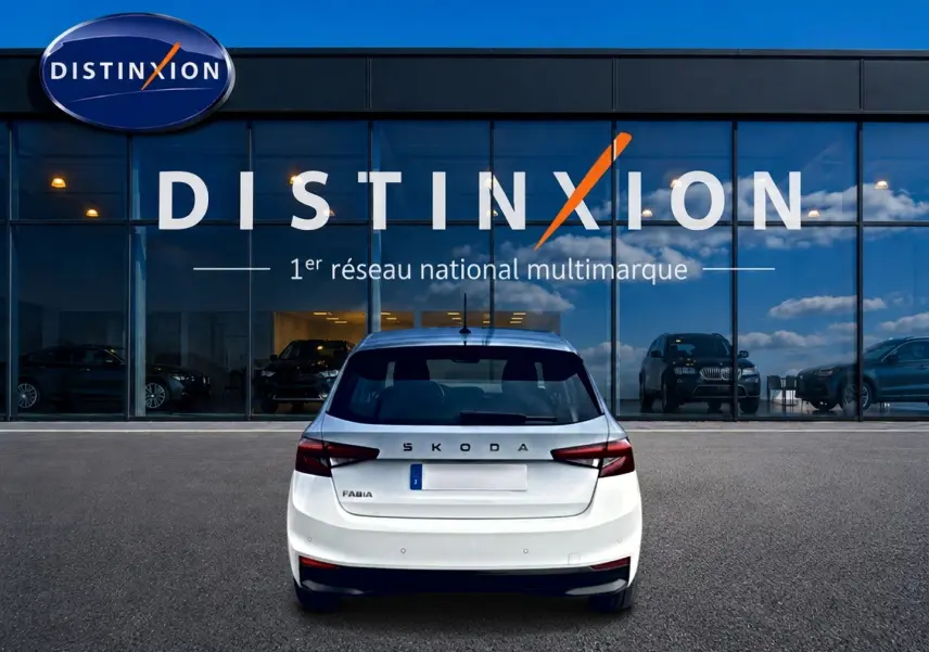 Vue arrière d'une Skoda Fabia blanche 2025 garée devant une vitrine avec logo Distinxion.