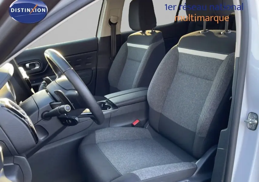 Vue intérieure côté conducteur du Citroën C5 Aircross blanc, montrant les sièges tissu et cuir gris et le volant multifonction.