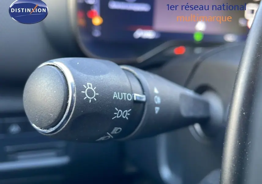 Gros plan sur la commande des phares en mode automatique dans l’habitacle d’un Citroën C5 Aircross blanc Okenite 2025.