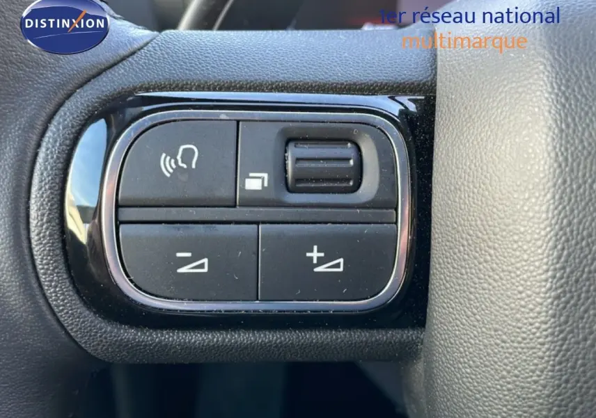 Gros plan sur les commandes de réglage vocal et volume au volant du Citroën C5 Aircross 2025 blanc Okenite Metal.