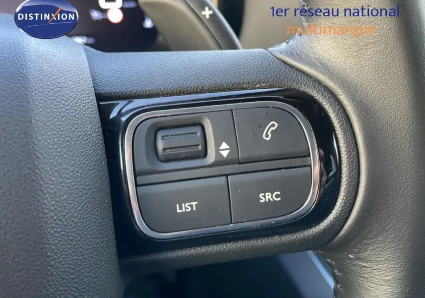 Gros plan sur les commandes au volant du Citroën C5 Aircross 2025, finition tissu noir, avec boutons de gestion audio et appel.