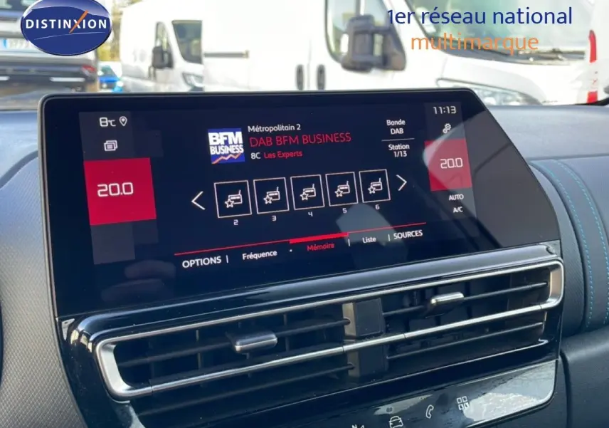 Vue intérieure centrée sur l'écran tactile du tableau de bord du Citroën C5 Aircross blanc, affichant la radio numérique.