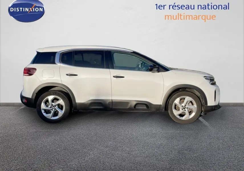 Vue de profil côté gauche d'un Citroën C5 Aircross blanc Okenite avec jantes alliage et protections noires basses.