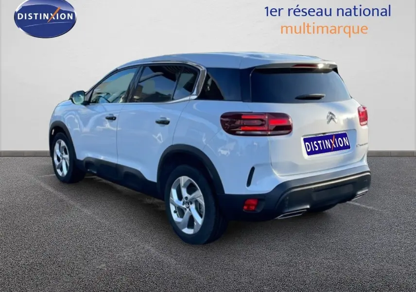 Vue 3/4 arrière droite d'un Citroën C5 Aircross blanc Okenite Metal avec toit noir et feux arrière LED.
