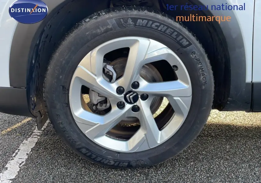 Gros plan sur la roue avant droite d’un Citroën C5 Aircross blanc Okenite avec jante alliage et pneu Michelin.