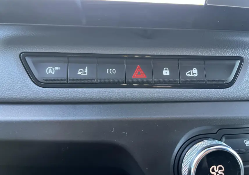 Vue rapprochée des boutons de commande sur la planche de bord du Renault Master blanc, avec alerte et verrouillage.