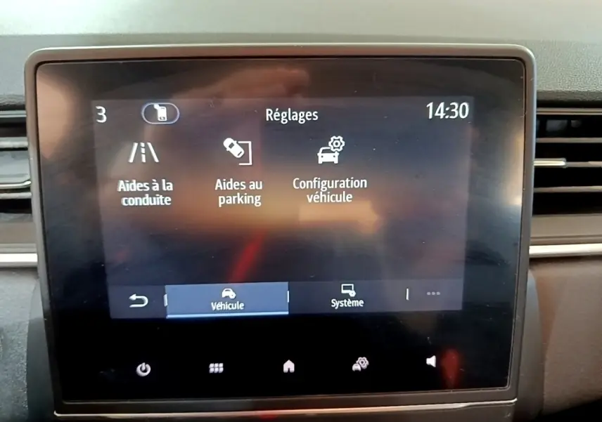 Écran tactile central du tableau de bord du Renault Captur Business noir, affichant les réglages d’aides à la conduite et au parking.