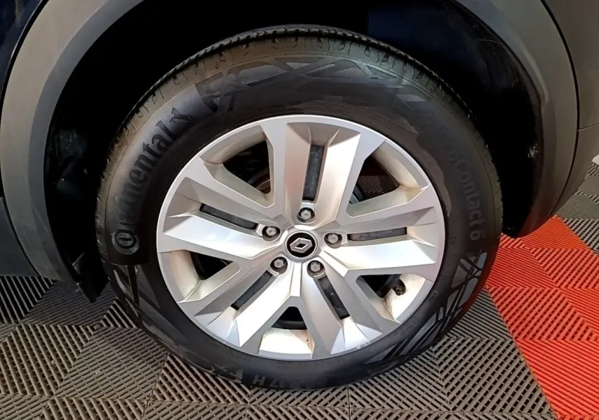 Gros plan sur la roue avant droite du Renault Captur noir 2021 avec jante alliage et logo Renault au centre.